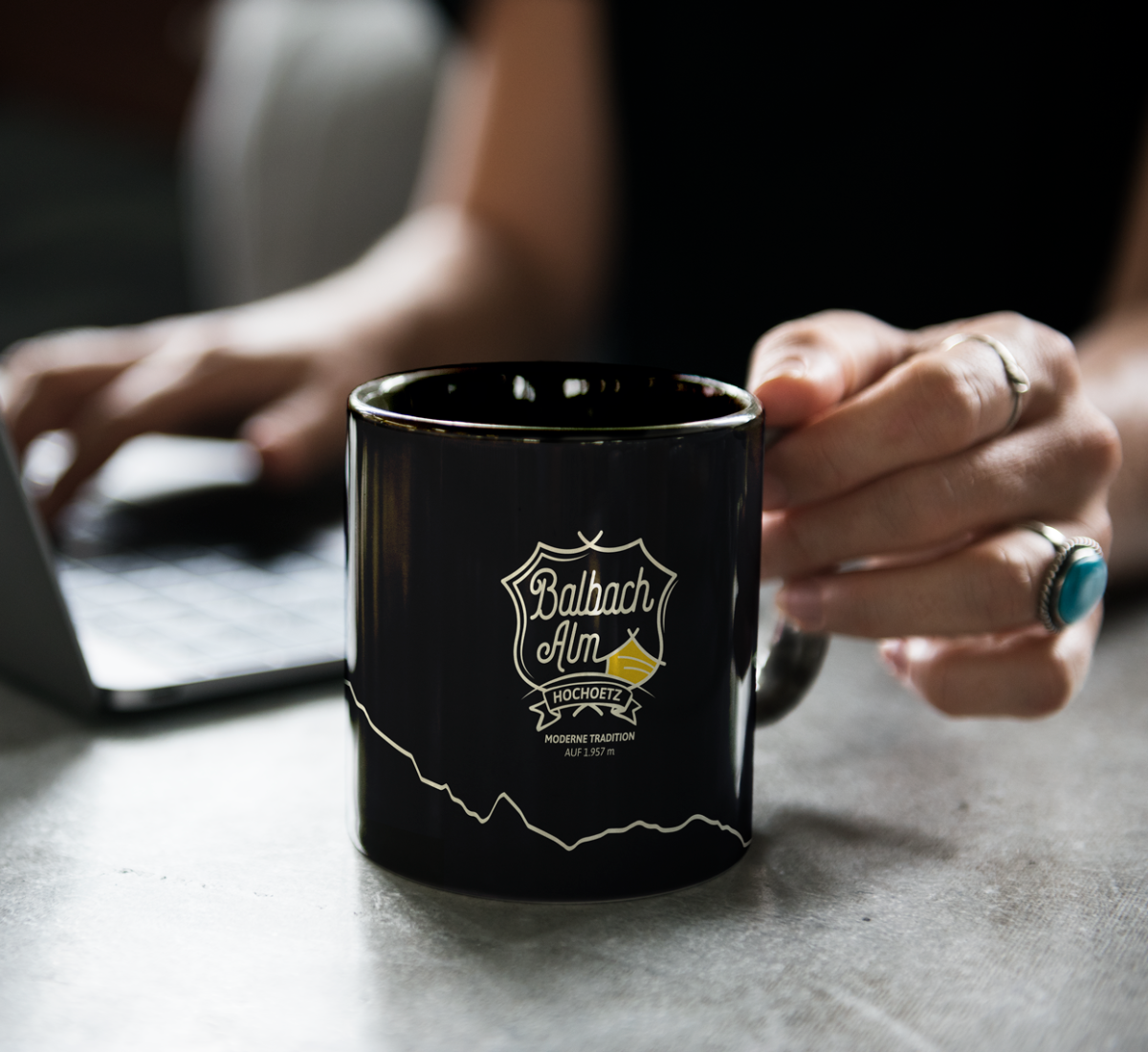 Eine Tasse mit dem Logo der Balbach Alm